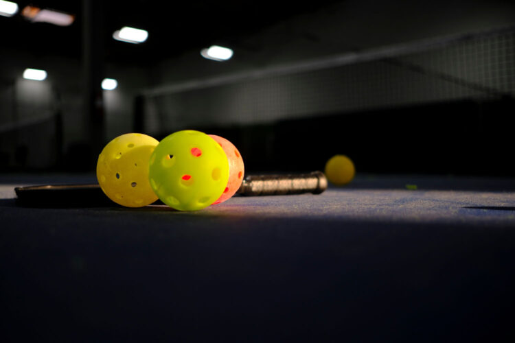 pickleballs on indoor court in sun